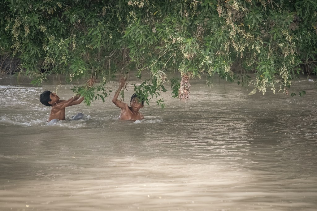 Children wade through a flooded canal in Pakistan, where this year’s monsoon rains have left many families without homes, safe water or schooling. (file photo)